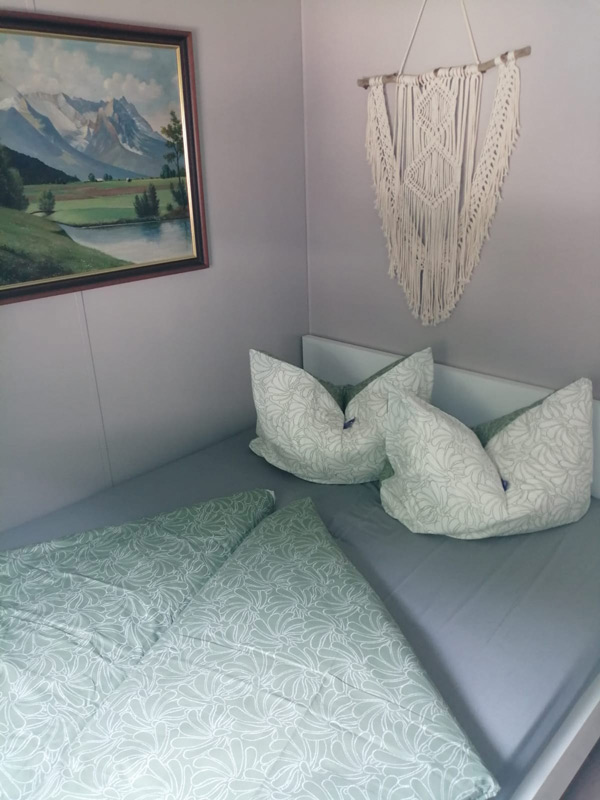 Schlafzimmer mit Wandbild und Makrame