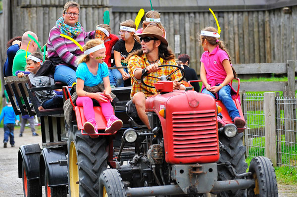Traktor mit Kindern fährt beim Kinderfest durchs Resort