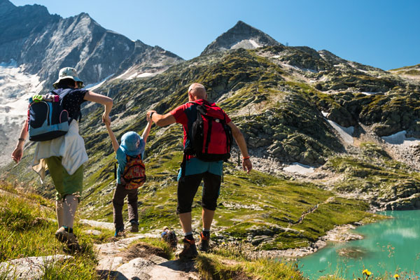 Großeltern wandern mit Enkel durch die Berge